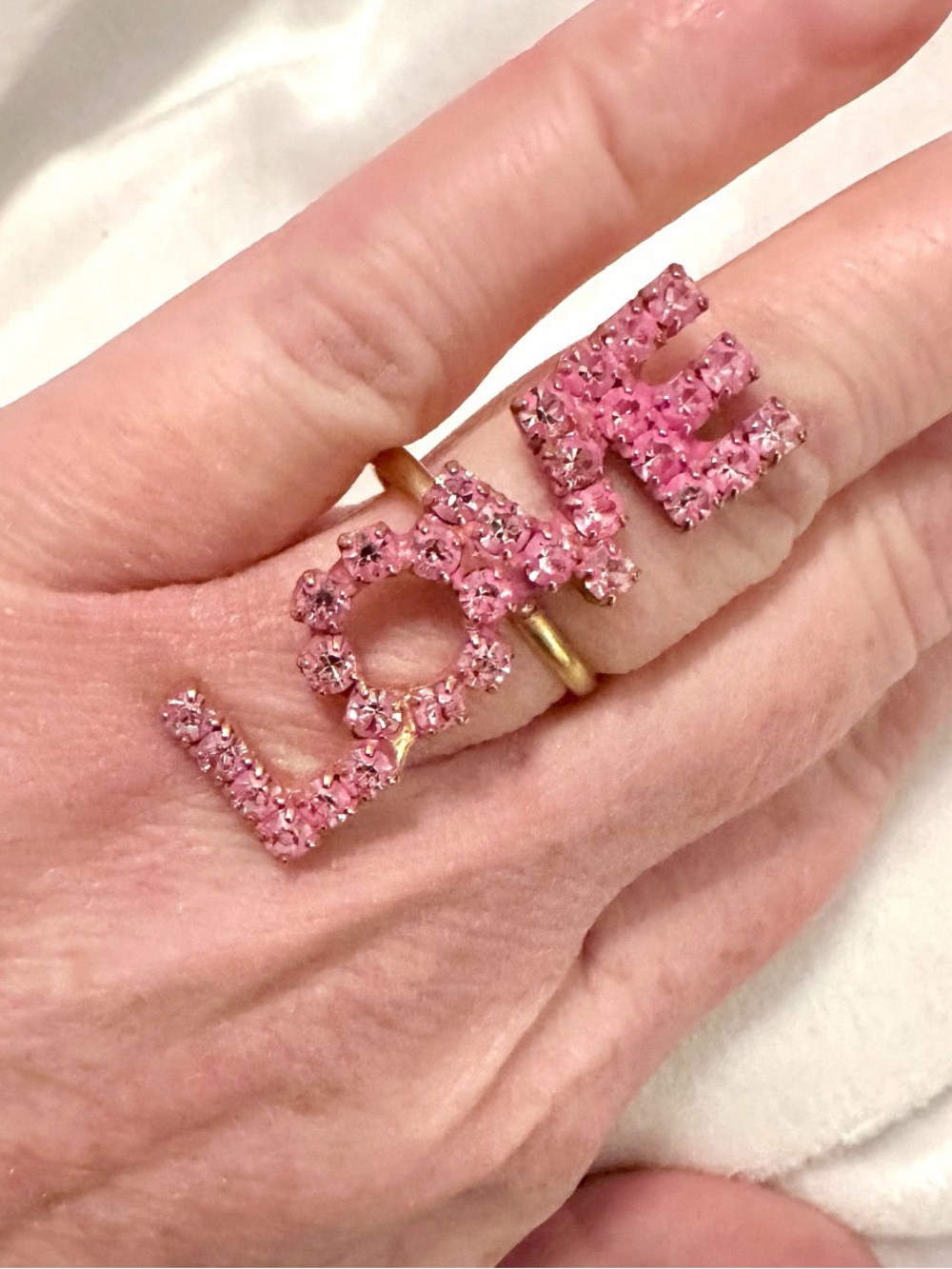 Tova LOVE statement Ring featuring pink crystals set in a gold-tone band